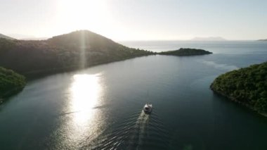 Yaz lüks modern tekne gezisi. Beyaz yat. Yelkenli. Derin mavi sulardaki beyaz teknenin görüntüsü. Yat gezintisi yapan zengin yatın yukarıdan görünüşü. Lüks gemiyle yaz yolculuğu.