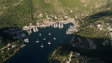Yatçılık. Lüks yelkenli. Yaz lüks modern tekne gezisi. Derin mavi sulardaki beyaz teknenin görüntüsü. Yat gezintisi yapan zengin yatın yukarıdan görünüşü. Lüks gemiyle yaz yolculuğu.