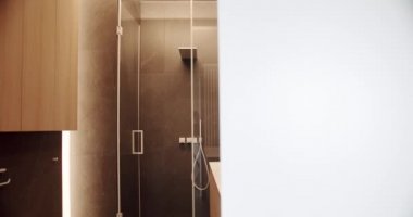 Lüks Banyo İçi, kahverengi renkli minimalist iç mekan, banyo aksesuarları, ayna ve duş başlığı, küvet modern tasarım. Lüks, rahat, beyaz bir daire. Basitlik tasarımı olan tuvalet.