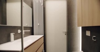 Basitlik tasarımı olan modern banyo. Lüks Banyo İçi, kahverengi renkli minimalist iç mekan, banyo aksesuarları, ayna ve duş başlığı, küvet modern tasarım. Lüks konforlu daire.