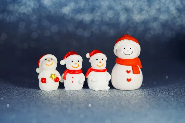 Четыре Фигуры Снеговика Блестящем Бумажном Фоне Рождественские Декоративные Улыбающиеся Снеговики — стоковое фото