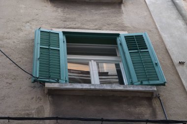 Eski bir evin yeşil panjurlu penceresi..