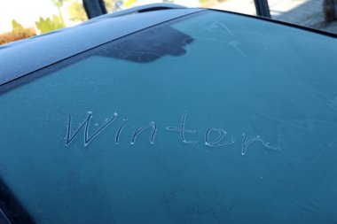 Kış - donmuş bir arabanın camında yazı.
