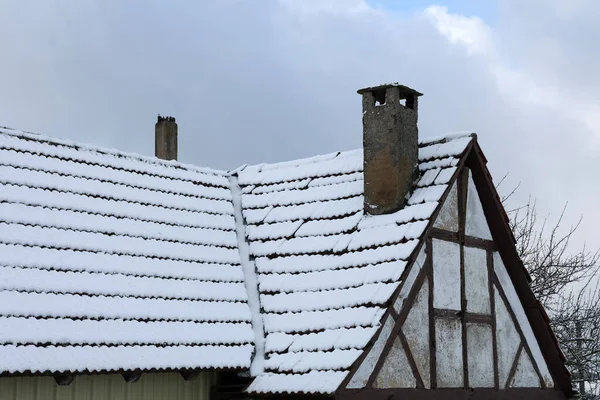 Il tetto di una vecchia casa è coperto di neve in inverno — Foto Stock