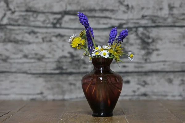 A vase with spring flowers is on the table — Fotografia de Stock
