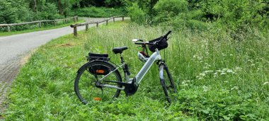 Yolda bir e-motosikletle bahar manzarası.