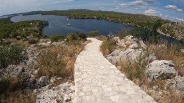Hırvatistan 'ın Sibenik kenti yakınlarındaki St. Ante kanalı kıyısında yürüyüş yolu.