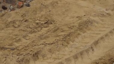 Yol yapımı ve onarımı. Şehir sokağı. Kumda lastik izleri, inşaat malzemeleri.