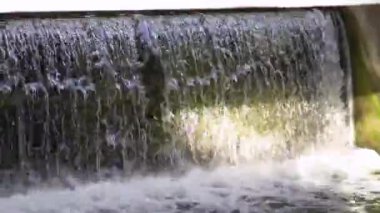 Old dam on the river. Close-up footage of the waterfall.