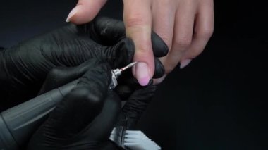 Manikür yaptırmaya çalışıyorum. Güzellik salonu elleri ve tırnakları koyu bir arka planda. Video görüntüleri