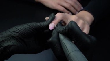 Manikür yaptırmaya çalışıyorum. Güzellik salonu elleri ve tırnakları koyu bir arka planda. Video görüntüleri
