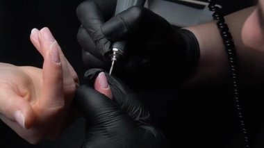 Manikür yaptırmaya çalışıyorum. Güzellik salonu elleri ve tırnakları koyu bir arka planda. Video görüntüleri