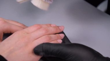 Manikür yaptırmaya çalışıyorum. Güzellik salonu elleri ve tırnakları koyu bir arka planda. Video görüntüleri