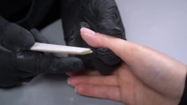 Manikür yaptırmaya çalışıyorum. Güzellik salonu elleri ve tırnakları koyu bir arka planda. Video görüntüleri