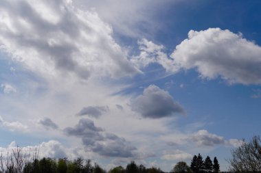 Mavi gökyüzünde güneş ışığında bulutlar.