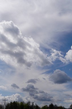 Mavi gökyüzünde güneş ışığında bulutlar.