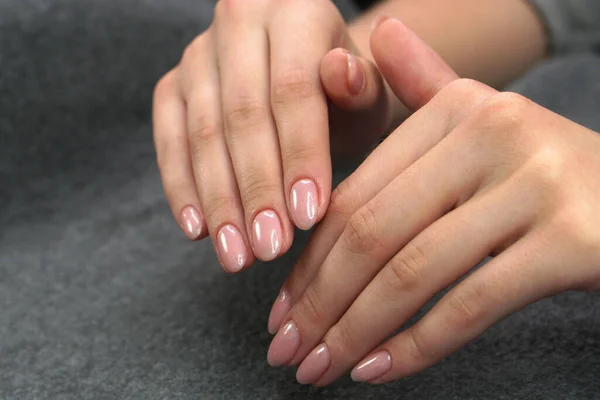 Women's hands after manicure and gel polish. Cosmetology procedure and skin care in a beauty salon.