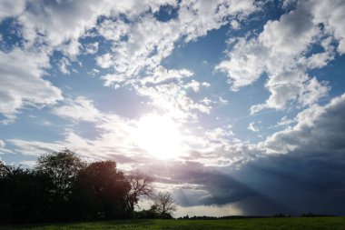 Mavi gökyüzünde güneş ışığında bulutlar.