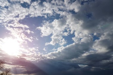 Mavi gökyüzünde güneş ışığında bulutlar.