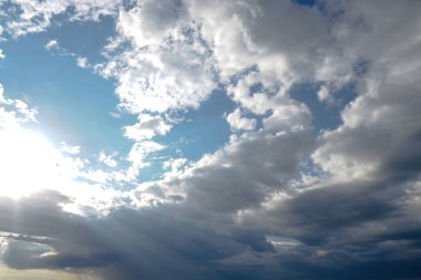 Mavi gökyüzünde güneş ışığında bulutlar.