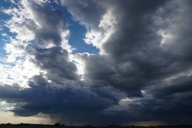 Mavi gökyüzünde güneş ışığında bulutlar.