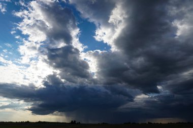 Mavi gökyüzünde güneş ışığında bulutlar.