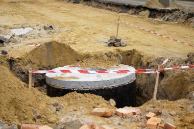 Kırmızı ve beyaz bariyerler tehlikeli bölgeyi koruyor. İnşaat alanı. Yıkımdan sonra yolun tamiri.