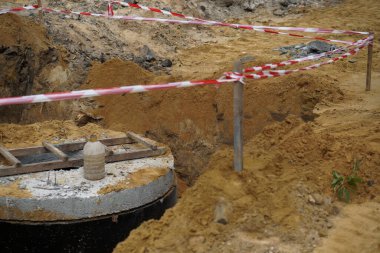Kırmızı ve beyaz bariyerler tehlikeli bölgeyi koruyor. İnşaat alanı. Yıkımdan sonra yolun tamiri.