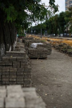 Gri kaldırım taşlarından bir palet. Yol yapımı ve onarımı. Şehir caddesi yıkımdan sonra.