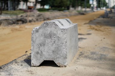 Yol yapımı ve onarımı. Şehir sokağı. Kumda lastik izleri, inşaat malzemeleri..