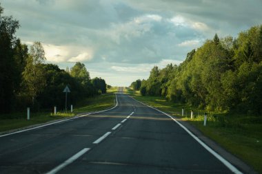 Ormanın içinden geçen boş bir otoyol. Güzel yaz manzarası arka planı. Seyahat