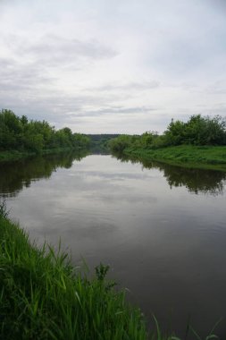 Güneşin son ışınlarıyla akşam manzarası. Yazın sabah nehir kenarında. Güzel doğa, tasarım için fotoğraf