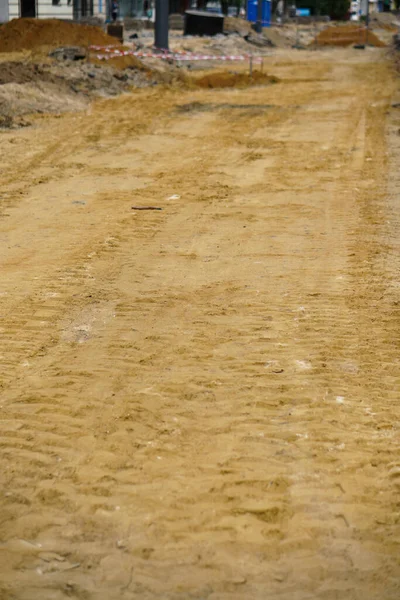 Tire track on yellow sand. Construction, repair of the street, roads.