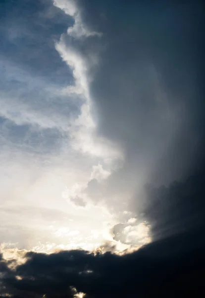 Dark, gloomy, stormy, rainy sky with rays of light. Terrible hurricane clouds. Background image for design