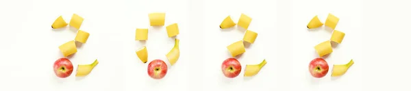 Date 2022 banner lined with numbers on a white background from cut ripe yellow bananas and a red sweet apple. — Stock Photo, Image