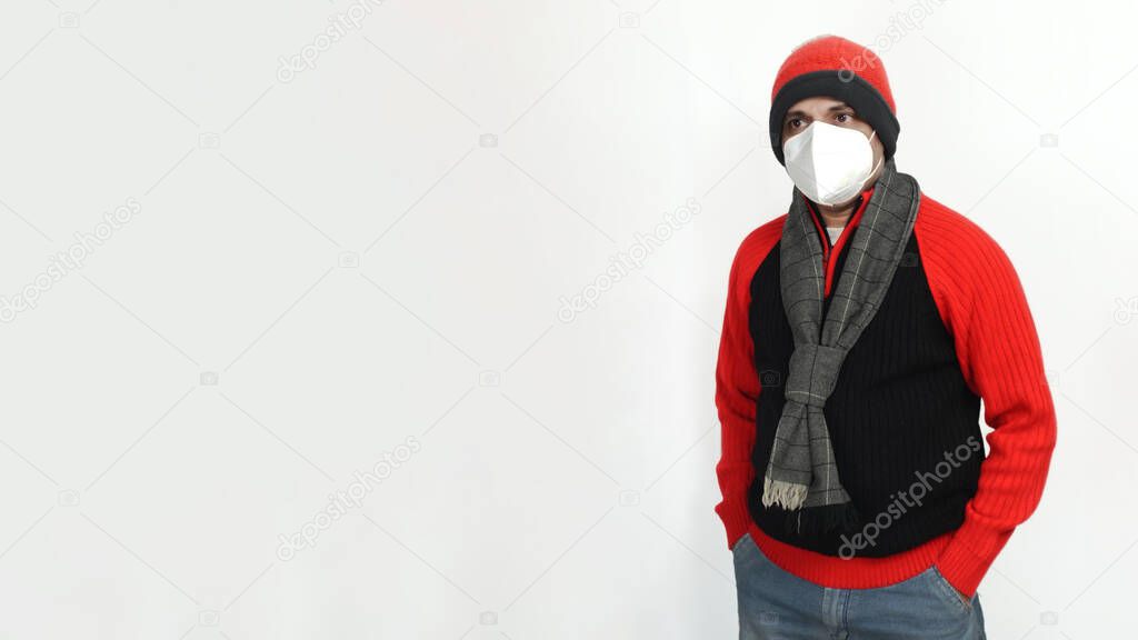 Young Indian Man Wearing a Woolen Sweater, Hand Gloves and Cap, Winter Season, Red and Black Sweater and Cap, Grey Hand Gloves, isolated in Off-White Background, Warm Clothes, Copy Space