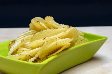 Tahta Masa 'daki Yeşil Kare Wafers' da tuzlu patates gofretleri, Bir yığın gofret, Kopyalama Alanı, Cips Yığını, Yakından Görüntü, Kara Arkaplanda İzole Edilmiş