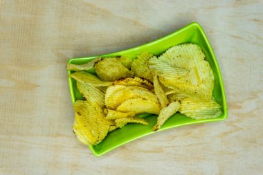 Tahta Masa 'daki Yeşil Meydan Gofreti' nde tuzlu patates gofretleri, Yığınla gofret, Kopya Alanı, Cips Yığını, Top View