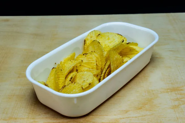 Tahta Masa 'da tuzlu patatesli gofret yığını, kopyalama alanı, cips yığını, yan görüş.