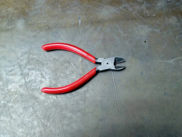 作業台に赤いハンドルの作業用ニッパー — ストック写真