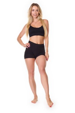 A young woman posing in a sports outfit on a white background. High quality photo