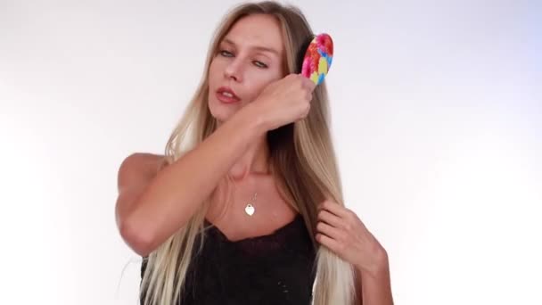 Blonďatá Modelka Učesává Vlasy Barevným Kartáčkem Vysoce Kvalitní Fullhd Záběry — Stock video