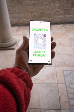 Restorana girmek için akıllı telefondan covid-19 pasaport gösteren kişi