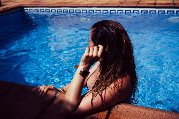 수영복을 입은 여자 가 수영장 타일에 의지하고 있다 — 스톡 사진