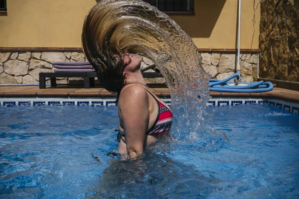 Caucasian woman flips hair in turquoise waters — Fotografia de Stock