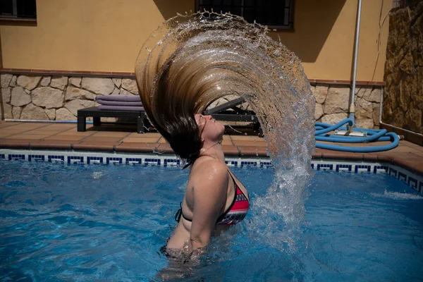 Caucasian woman flips hair in turquoise waters — стокове фото