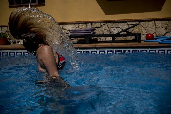 Caucasian woman flips hair in turquoise waters — стокове фото