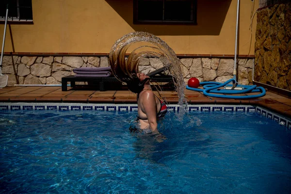 Caucasian woman flips hair in turquoise waters — стокове фото