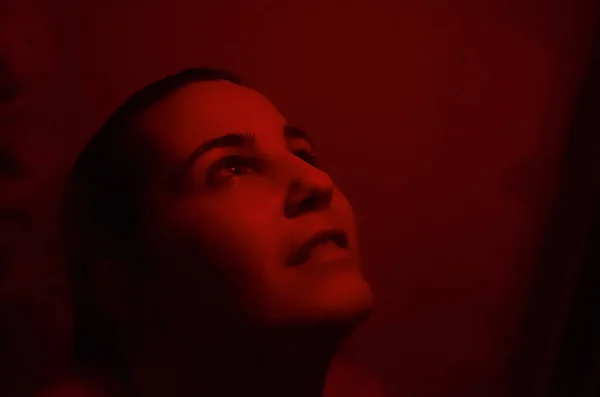 官能的な赤い光で画面の後ろにシャワーを浴びている女性 ストック写真