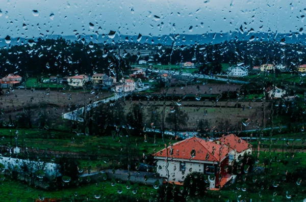 从有雨滴的窗户看到的村庄 — 图库照片